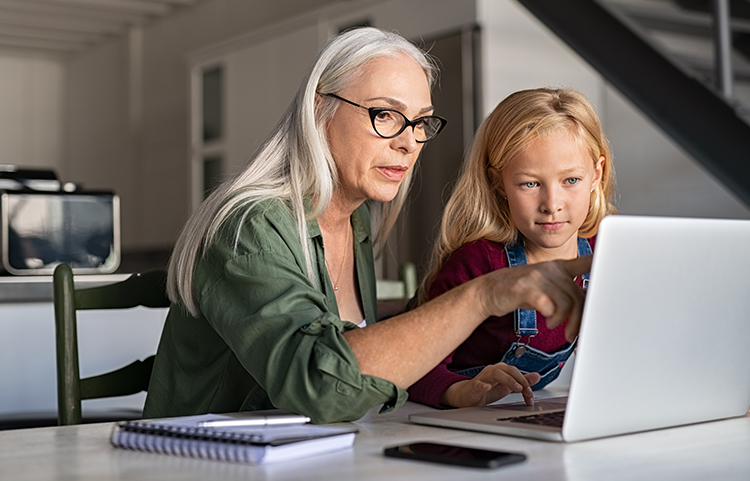 The mother is instructing her daughter on saving money, gesturing towards the laptop.